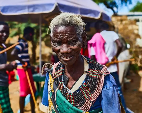 An elder woman in traditional attire smiling