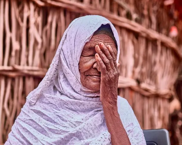 An elder woman wearing a hijab with a gentle expression